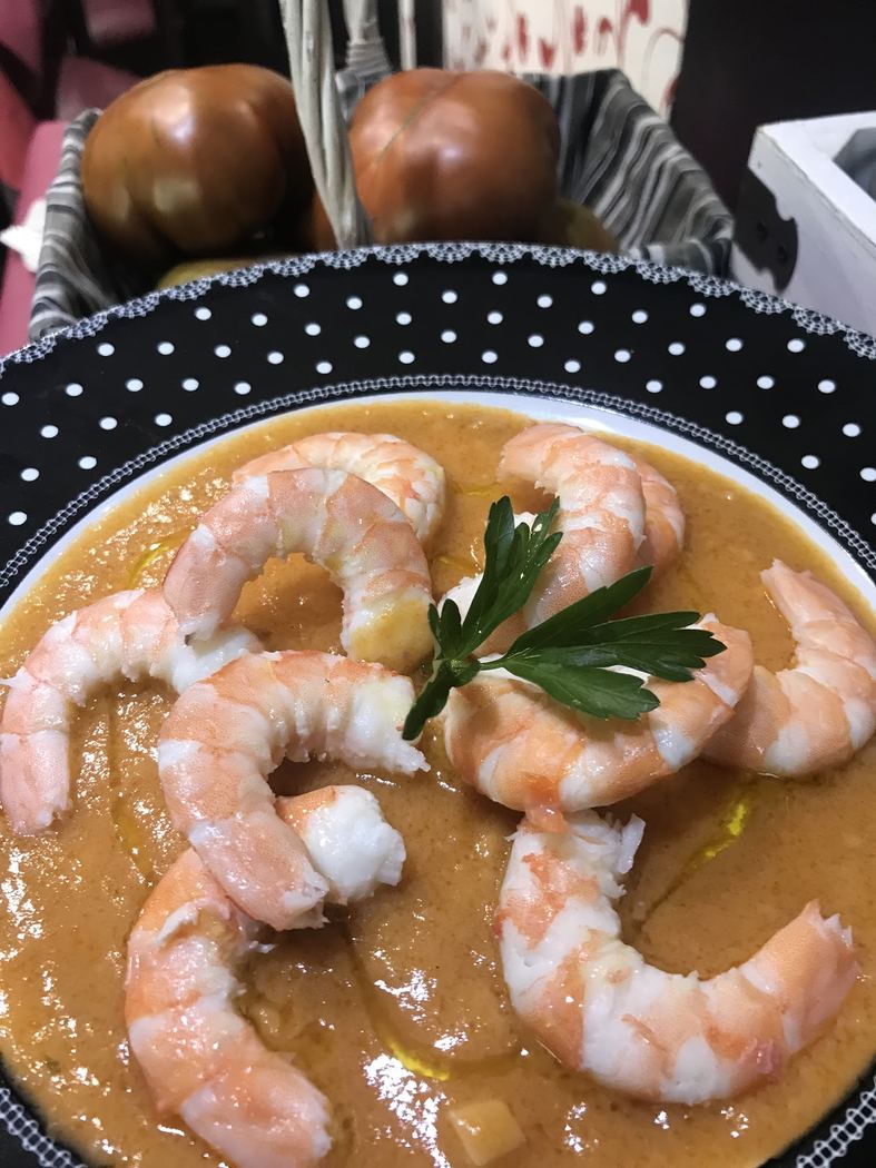 Crema de marisco con gambas al ajillo, servida caliente.
