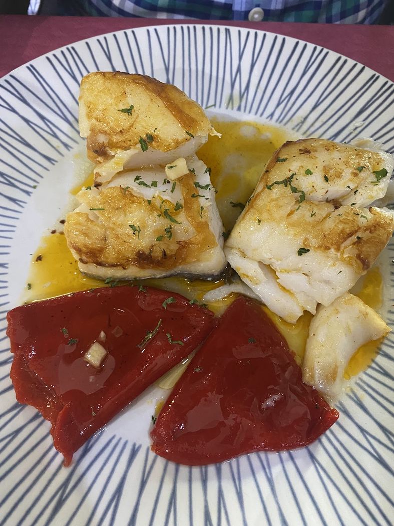 Bacalao confitado con pimientos asados, un plato principal de pescado.
